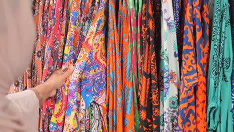 a woman shopping for fabric in a market