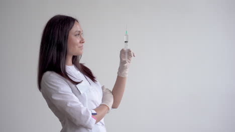 female doctor holding a syringe with a vaccine