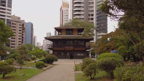 a traditional japanese house on an exuberant city, surrounded by lots of trees in a calm and quiet environment, creating a perfect place to relax