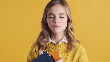 bored teenage caucasian girl student holding notebooks.