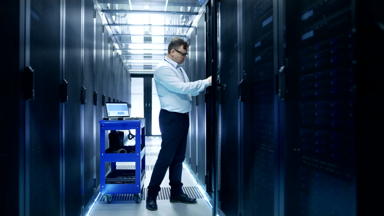 el ingeniero toma los discos duros del carro de accidentes e los instala en el servidor de rack. está trabajando en el centro de datos.