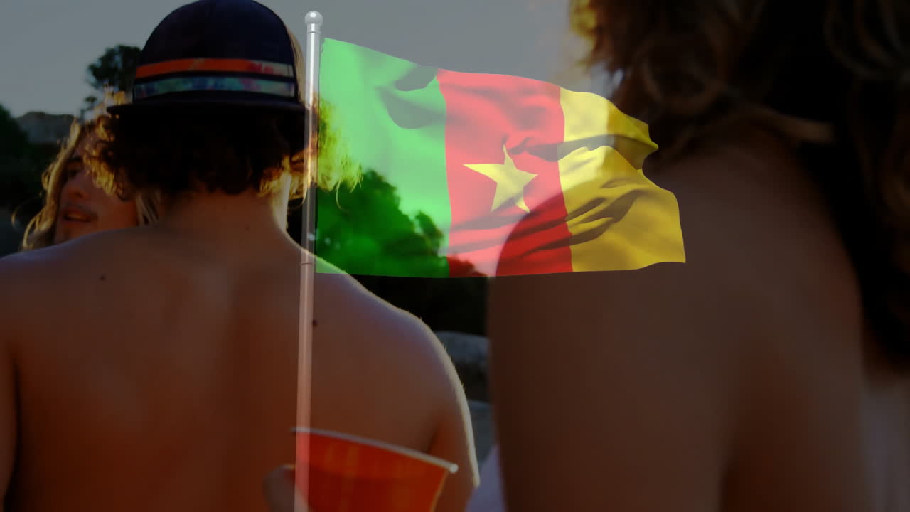 Cameroon flag animation waving over people relaxing on sunny day at beach
