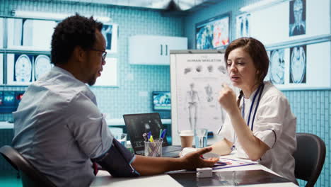 woman specialist taking pulse and blood pressure for african american patient
