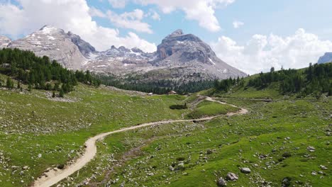 stunning summer of scenic dirt road cutting through alpine valley in dolomites