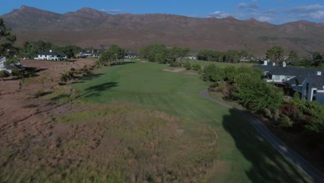 HD-Drone-tracking-shot-over-fairway-at-Pearl-Vally-Golf-Estate-with-Vast-Mountain-Range,-Western-cape,-Cape-Town,-South-Africa