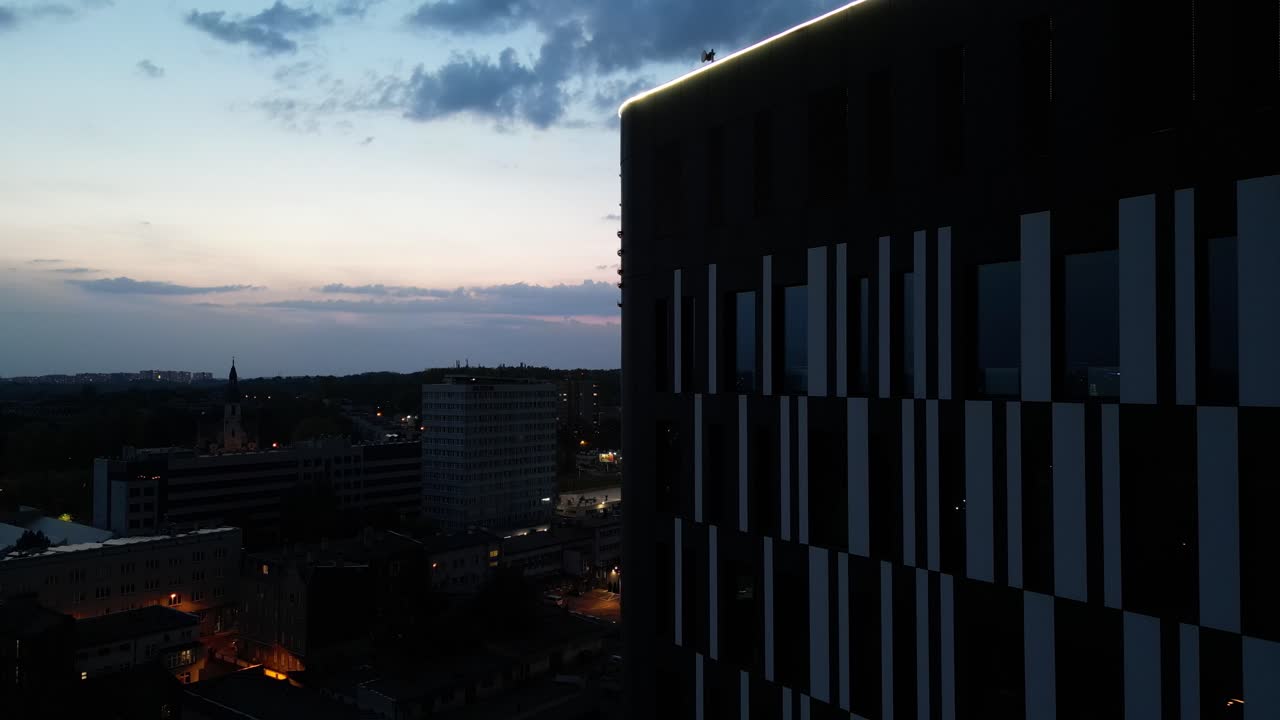 edificio de la torre dl en la ciudad de katowice, puesta de sol, tráfico, iluminación - dron aéreo 4k