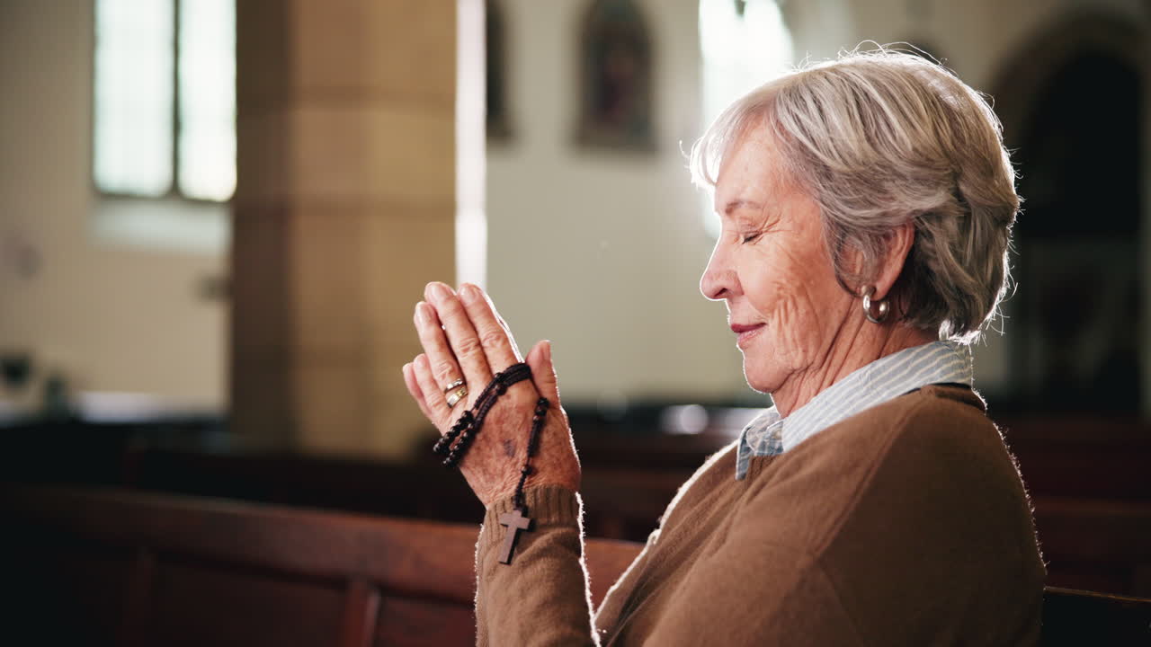 Elderly Woman Praying with Rosary in Church