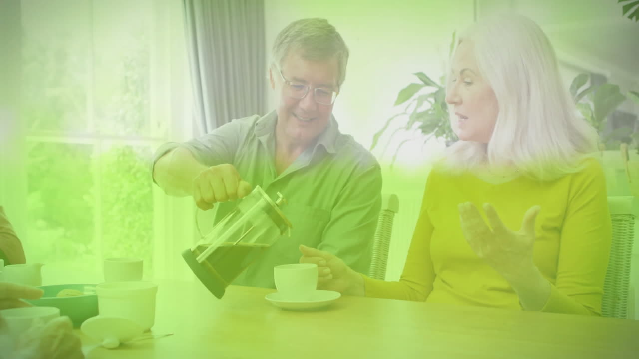 Elderly couple enjoying coffee together at home with green overlay animation