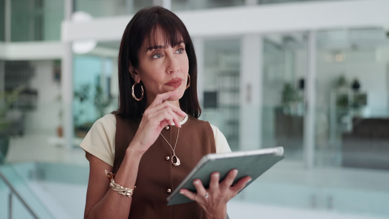 Thoughtful Businesswoman Using a Digital Tablet in a Modern Office