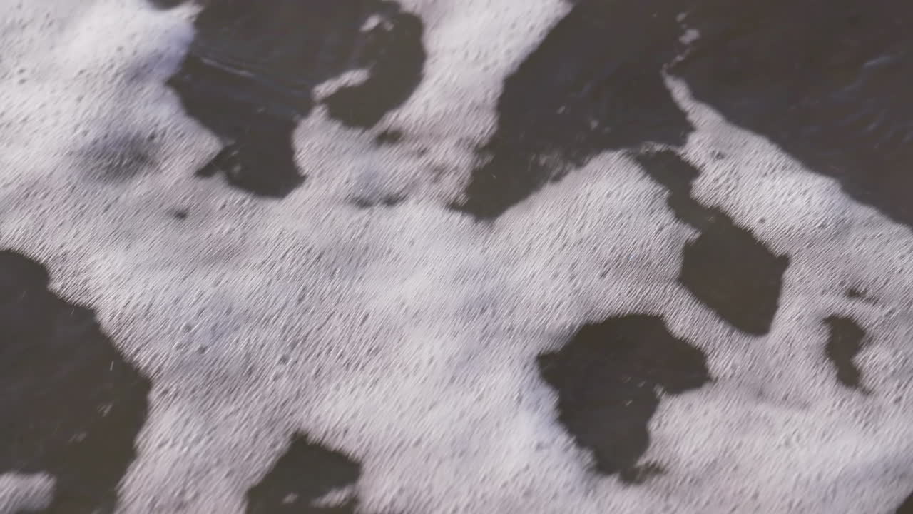 olas del mar corriendo en la playa durante la puesta de sol