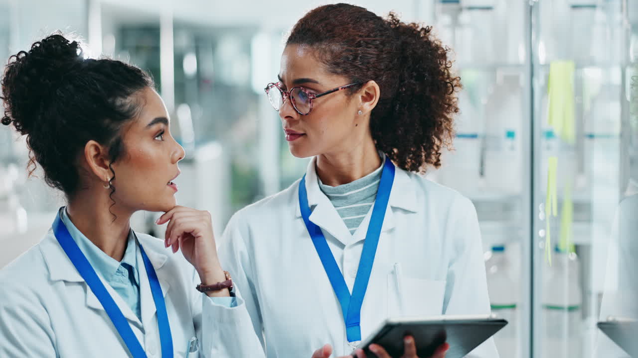 Two female scientists discussing research in a lab