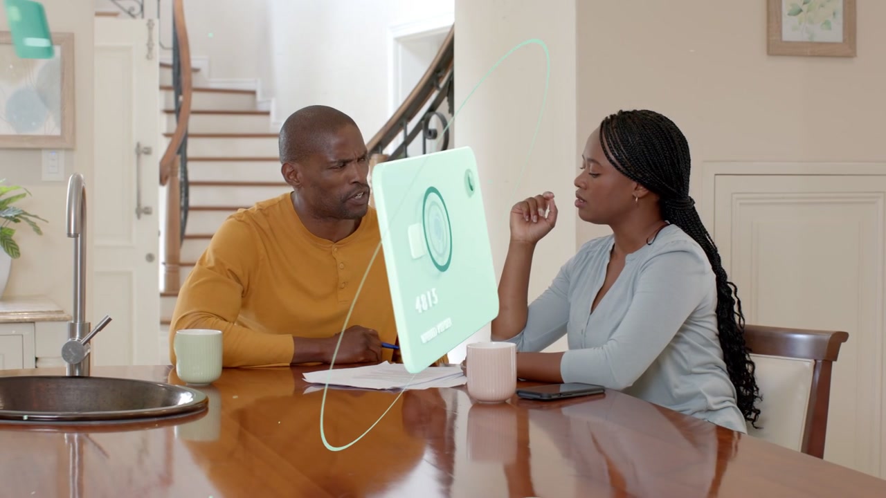 Man pointing to papers and causing green panels appearing, orbiting while couple reviewing finances