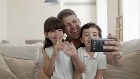 cheerful dad and two cute kids waving hello
