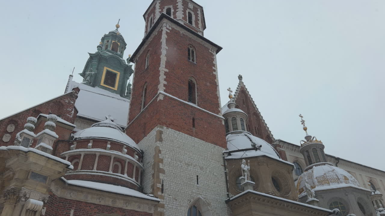 Ripresa inclinata dal basso verso l'alto della Cattedrale di Wawel a Cracovia, Polonia, in una giornata grigia e nevosa in slow motion