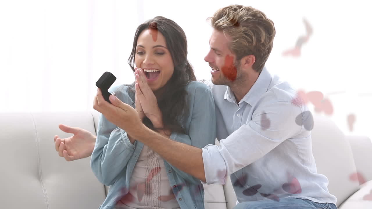 hombre inteligente pidiendo a su novia en matrimonio con los corazones volando