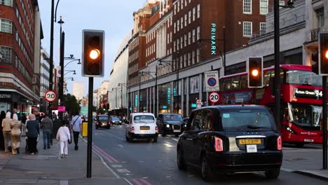 traffic and pedestrians on a bustling london street