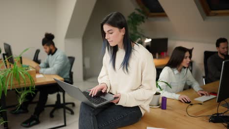 Focused-brunette-woman-sitting-on-the-table-with-laptop,-trying-to-solve-the-problem