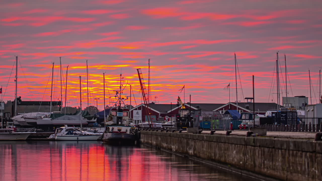 espectacular amanecer rojo sobre el puerto con reflejo en