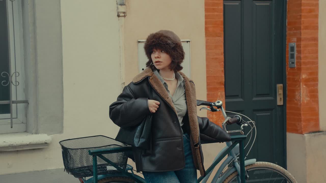 Junge Frau steht mit Fahrrad auf einer Stadtstraße
