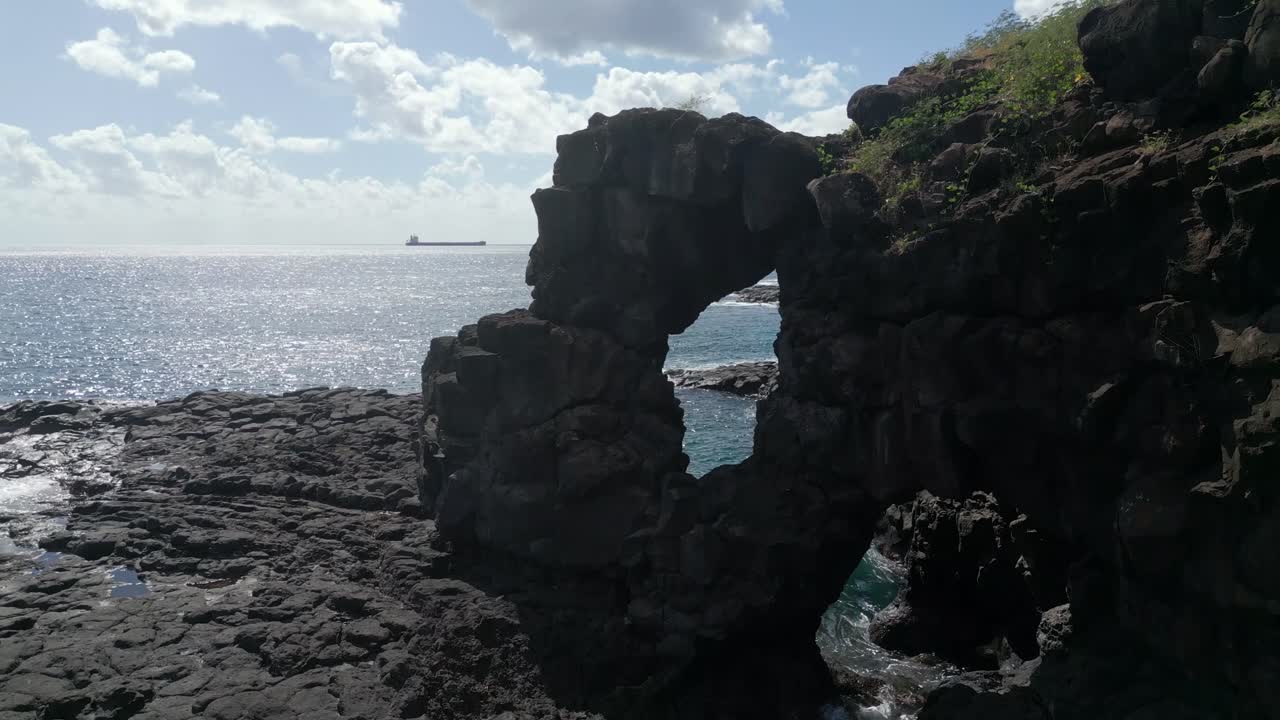 Mauritius - Albion - slow ascending view on the stone arch wit a boat in the background