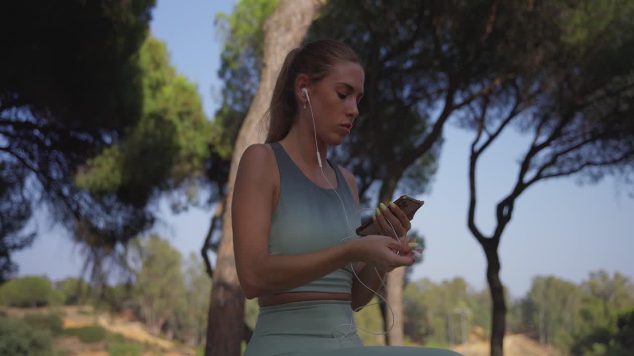 antes de comenzar, la atleta inserta auriculares en sus oídos y enciende la música en su teléfono