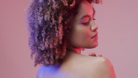mujer biracial con cabello oscuro sobre fondo púrpura, cámara lenta