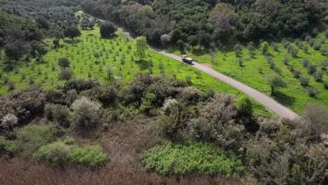 Following-a-construction-truck-on-a-lonely-road-along-green-fields-and-green-forests