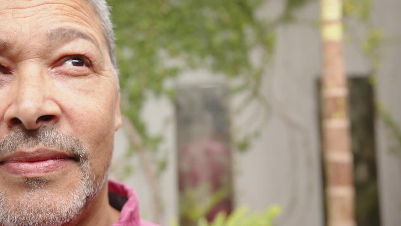 Smiling man with gray hair looking away, enjoying peaceful moment at home, copy space
