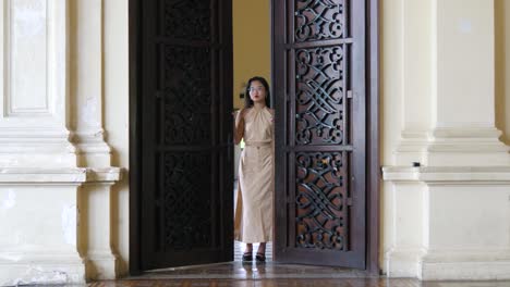 Beautiful-detailed-entrance-door-design,-young-woman,-stately-interior