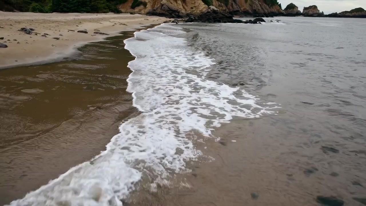 Dolci onde dell'oceano che si infrangono su una spiaggia sabbiosa.