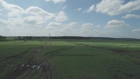 countryside field with dirt roads and cloudy sky