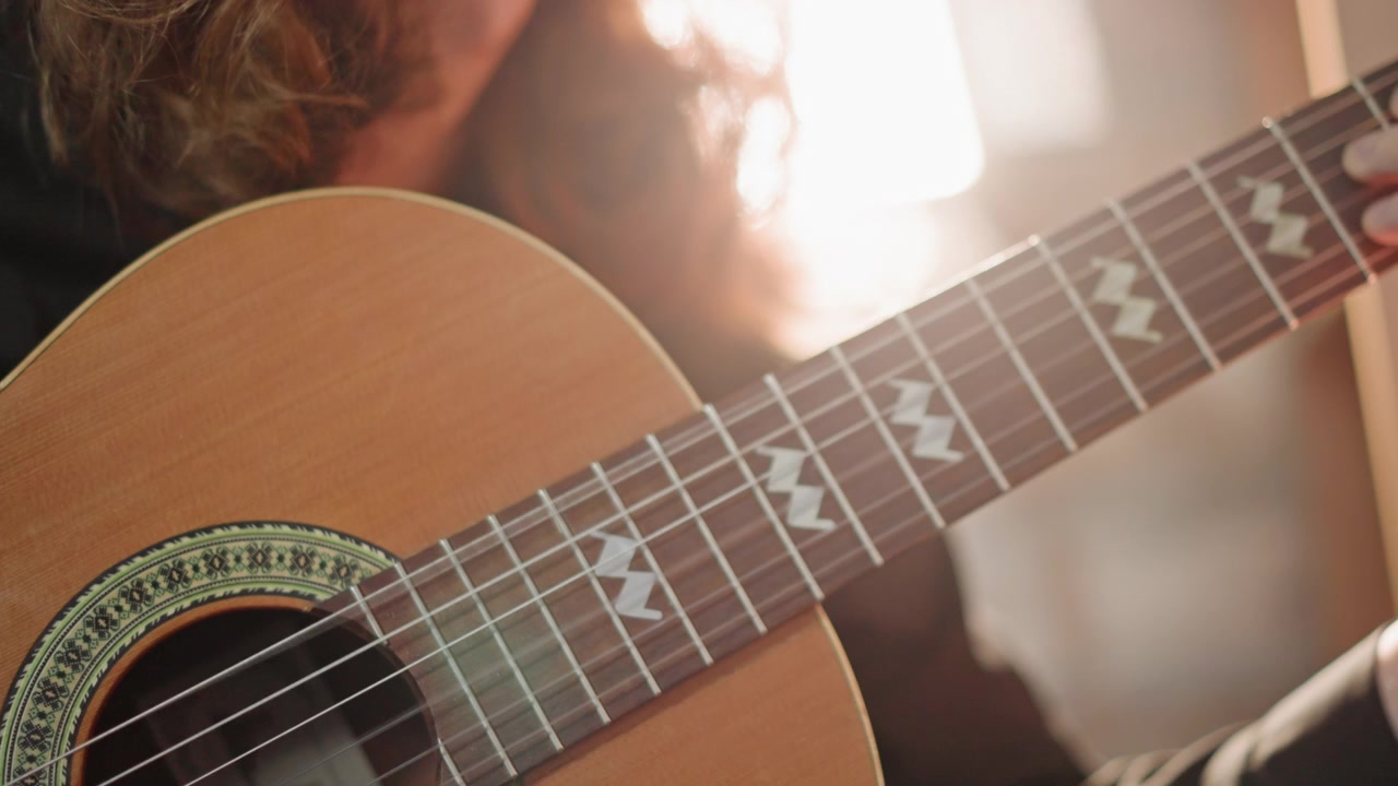Prove di chitarra in studio che enfatizzano le tecniche manuali e gli effetti di luce visivi, con una pratica focalizzata che evidenzia i movimenti delle mani e gli elementi di design dell'illuminazione.