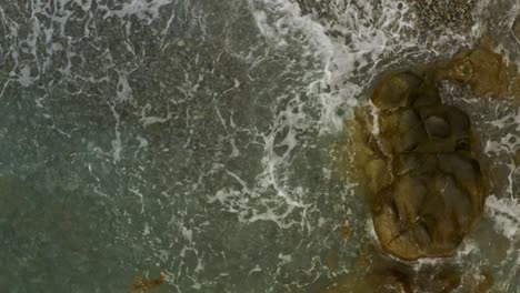 Vista-Aérea-De-Las-Olas-Del-Océano-Tocando-La-Costa,-Playa-Looc,-Ciudad-De-Surigao,-Filipinas