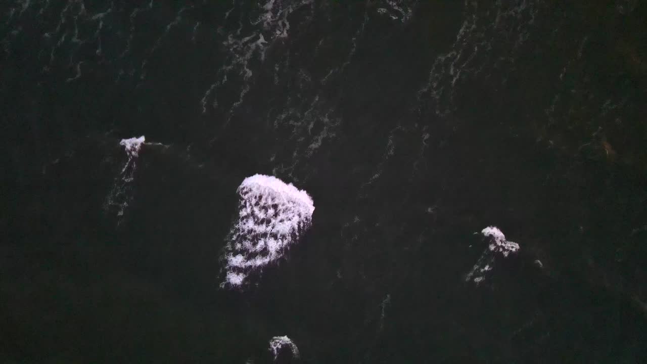 Drone view of a single wave crest breaking on the dark Baltic Sea surface off Rügen’s coast.
