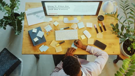 time lapse of businessman using pc and writing sticky notes at office desk