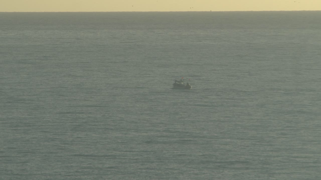 Fishing boat going far from the beach