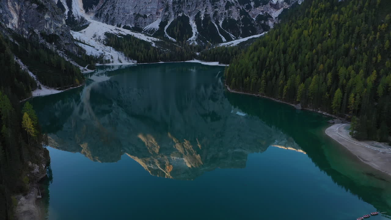 Cinematic tilting upward drone shot of the beautiful Lago Di Braies, Italian Dolomites, in South Tyrol Italy