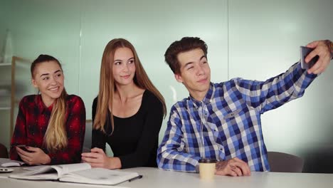 equipo de negocios creativo en una oficina moderna posa para una selfie con un teléfono. retrato de un equipo de negocios casual sonriente tomando selfies en