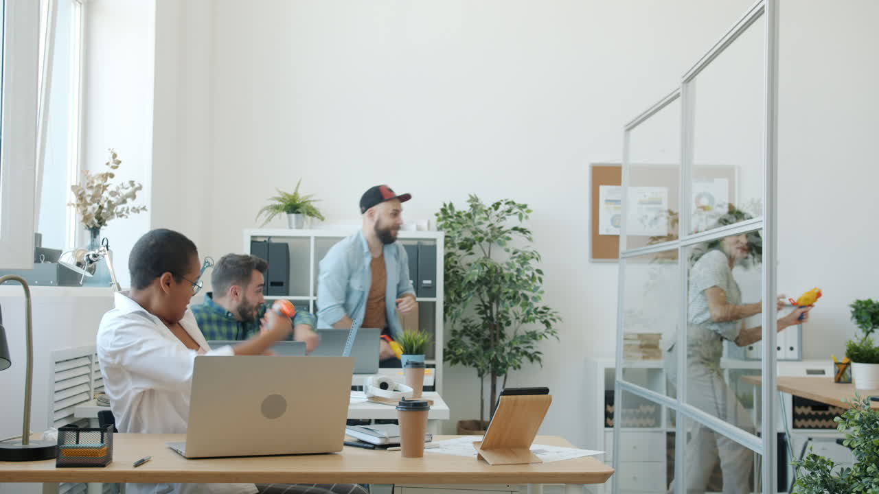 Office Colleagues Having Fun with Water Guns