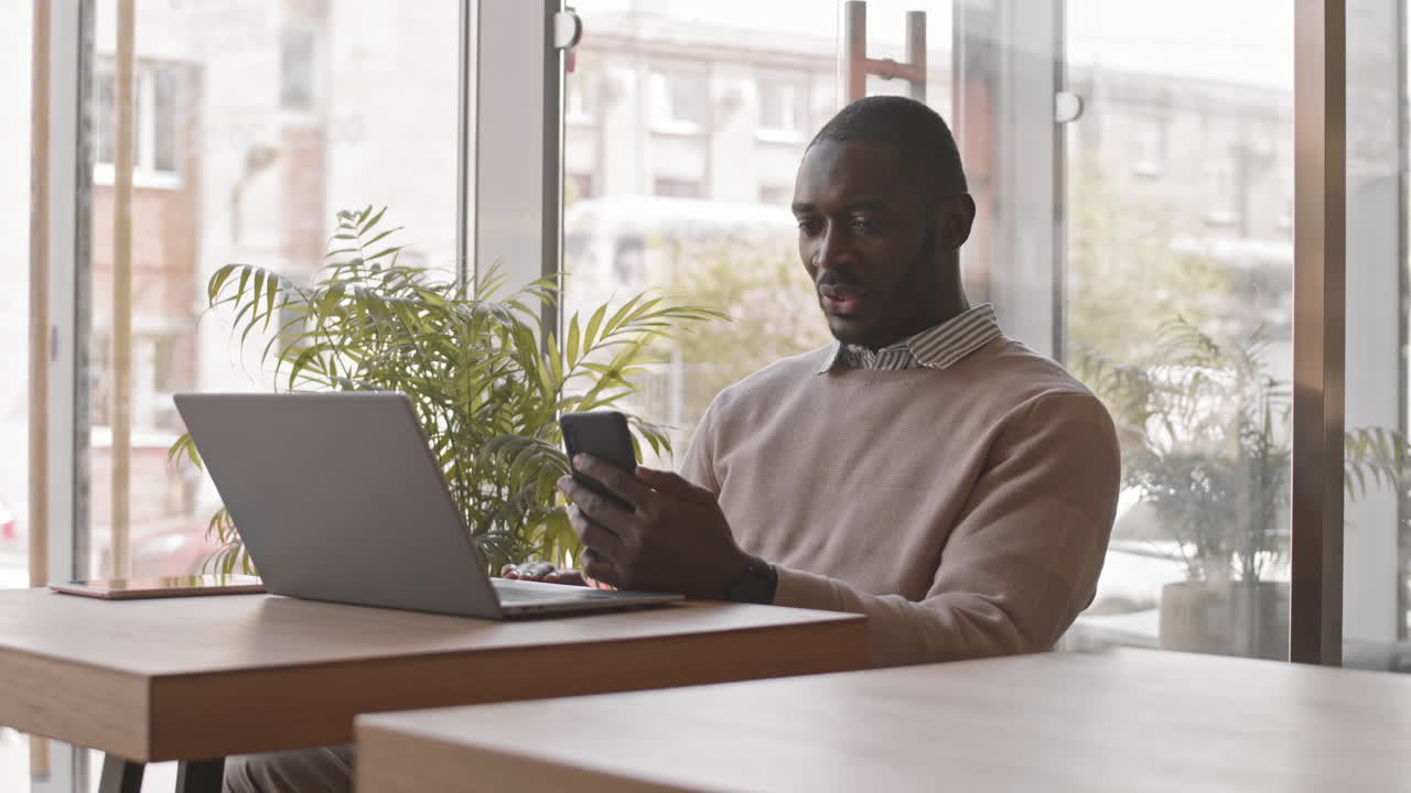Afro American Businessman Video Chatting in Cafe