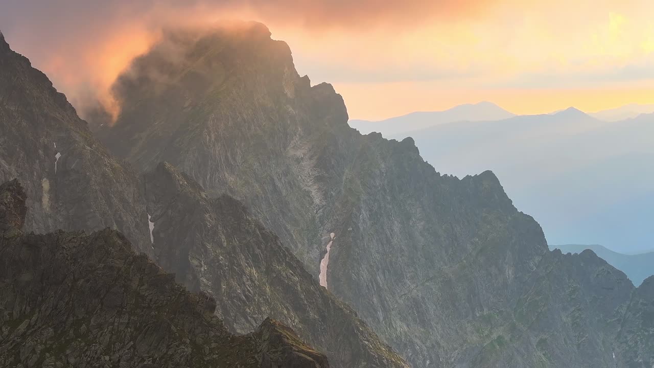 Ripresa con drone dinamica, lenta e stabile, di un paesaggio montano al tramonto in ambiente alpino, con creste affilate, in Austria.