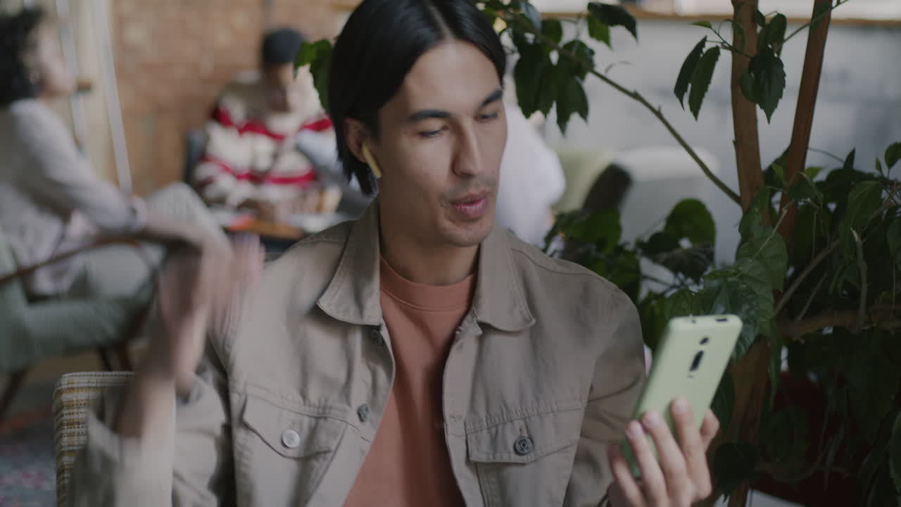 한 남자가 카페에서 비디오 통화를 하고 있다.