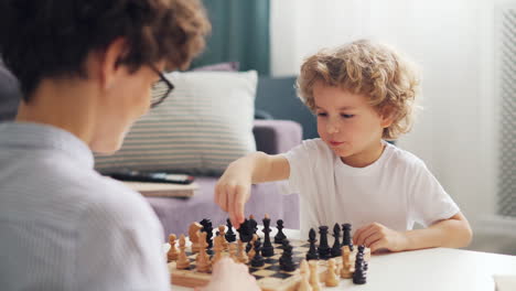 child and adult playing chess
