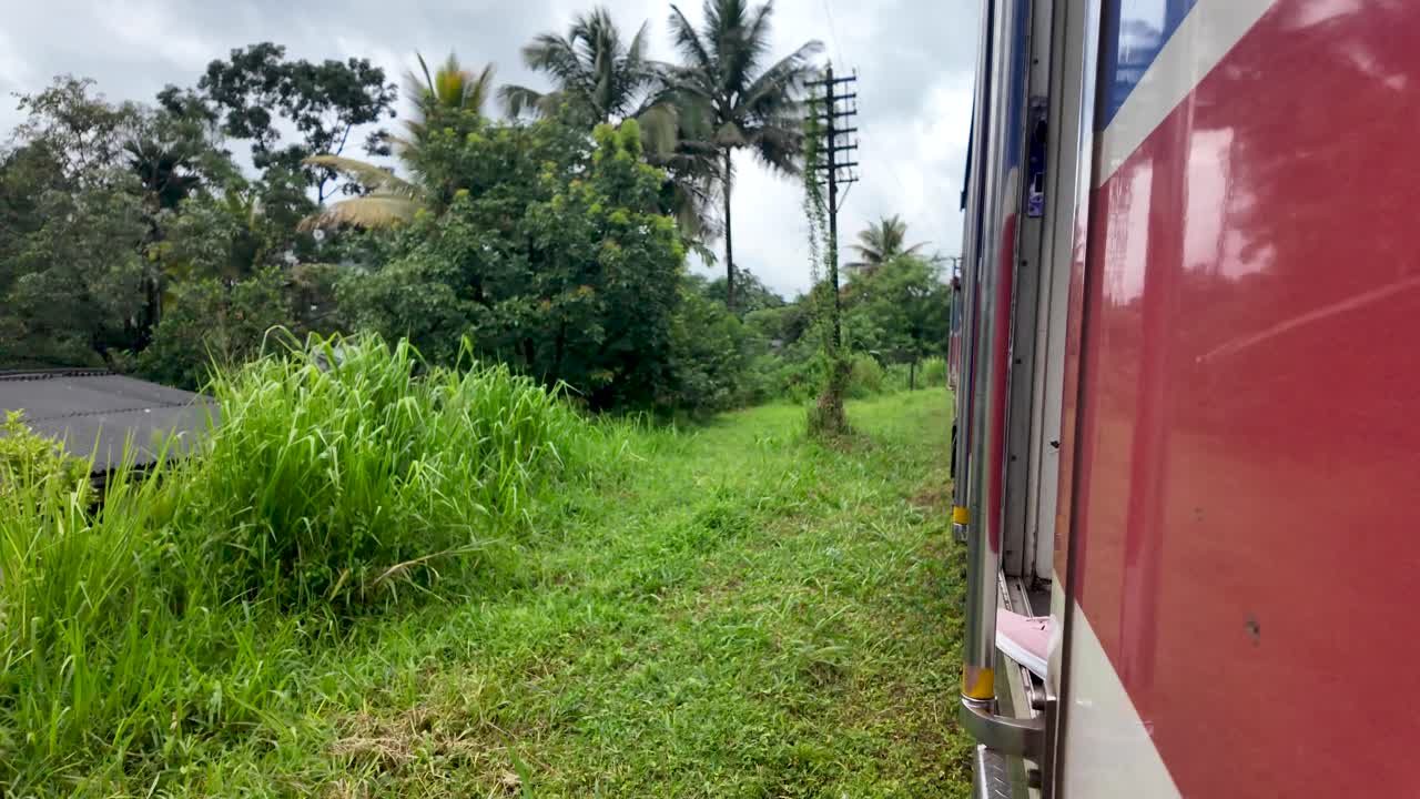 Experiencing the beauty of rural sri lanka as a train travels through lush green landscapes, offering a glimpse of local life