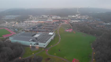 drone shot of public housing complex surrounded by grass and forests
