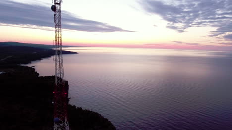 fotografía aérea de una torre de radio de telecomunicaciones al amanecer en el lago superior