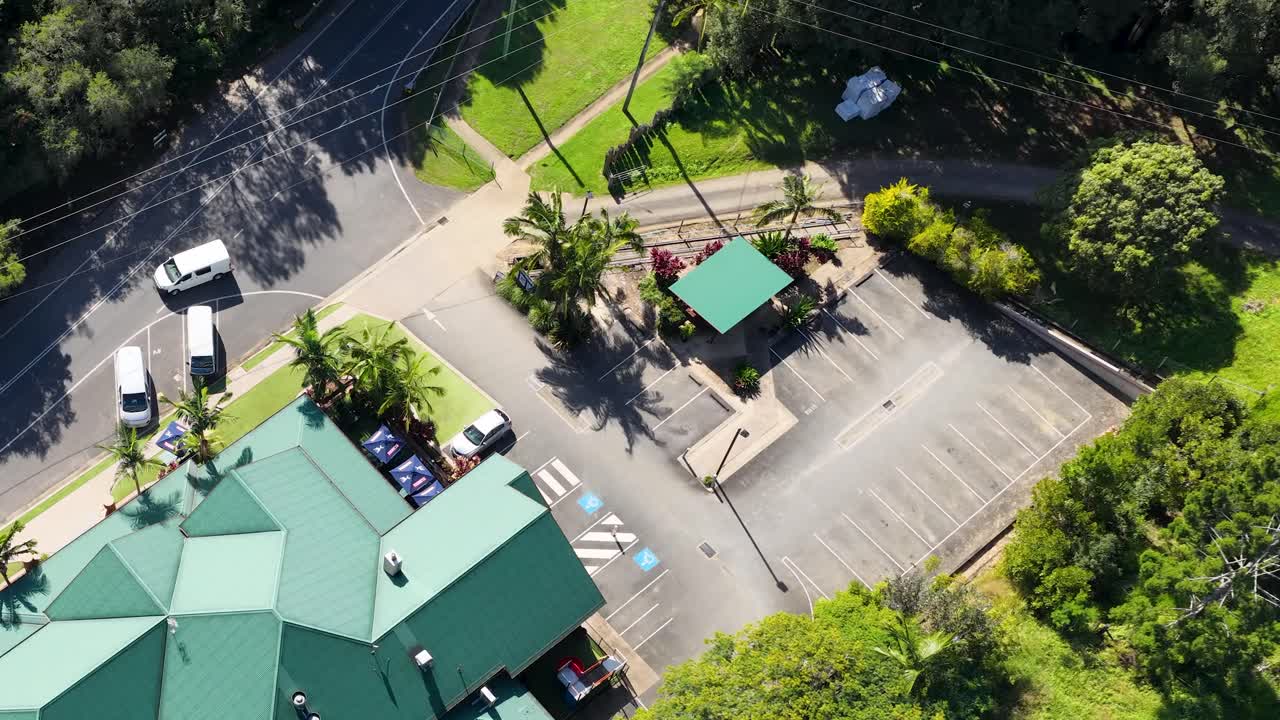 Aerial footage shows a parking lot and surrounding greenery in Uki, NSW, under bright daylight