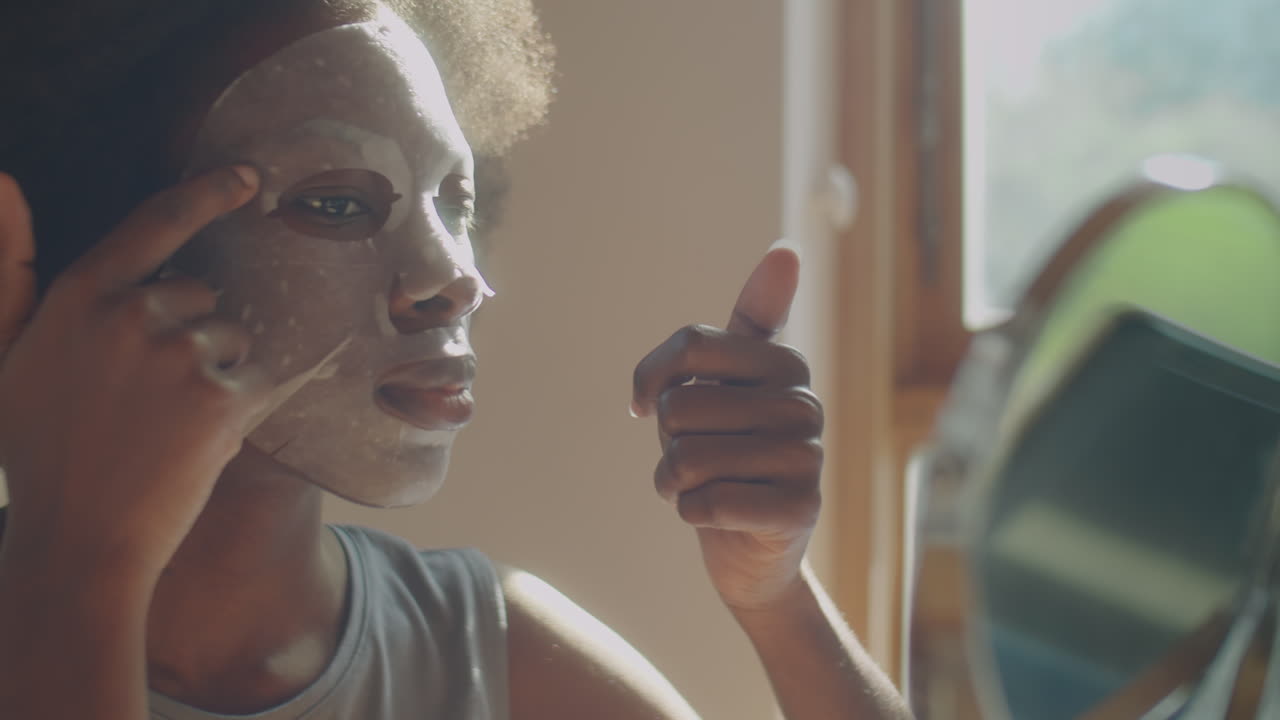African American Woman Using Sheet Mask at Home