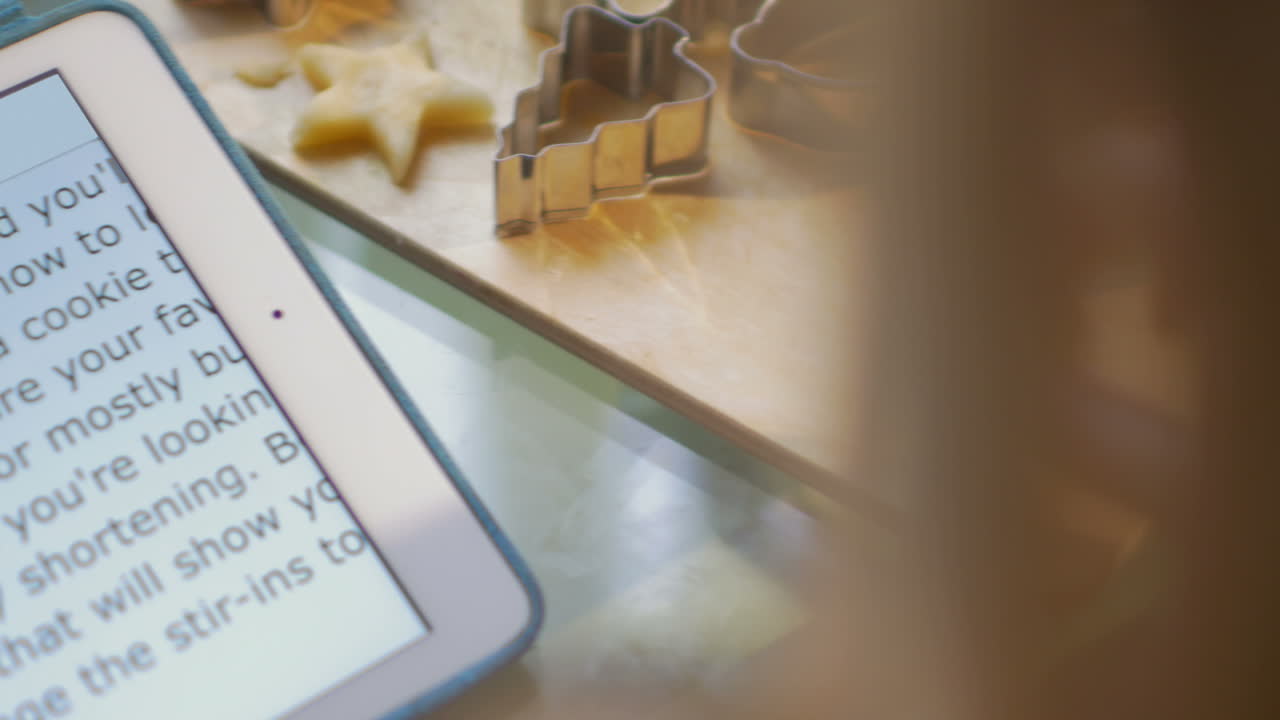 mujer haciendo galletas usando receta en el pad