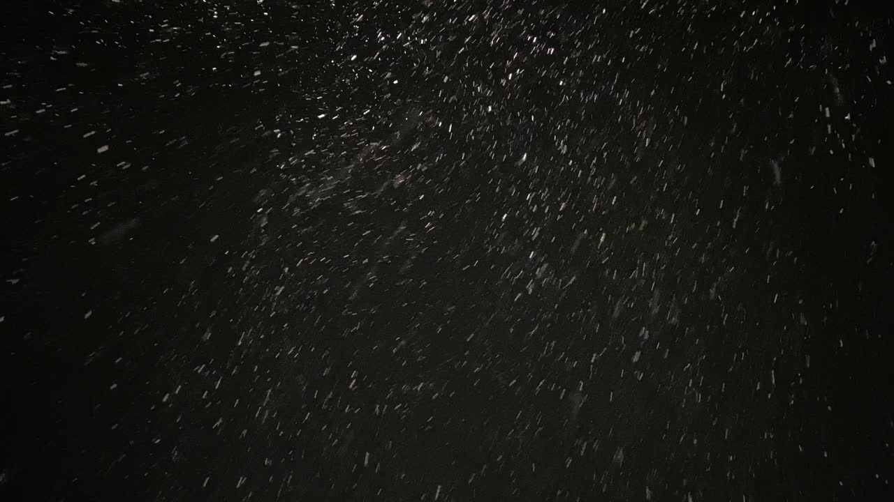 밤 하늘에서 많은 눈이 내리고 있습니다.